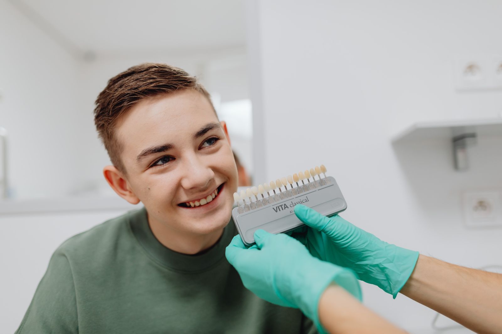 Joven sonriendo durante su consulta dental